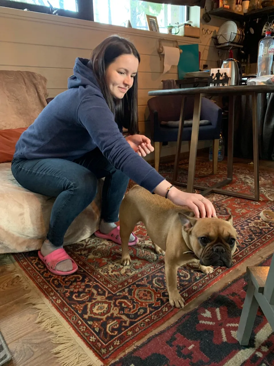 Anastasia petting a small brown dog